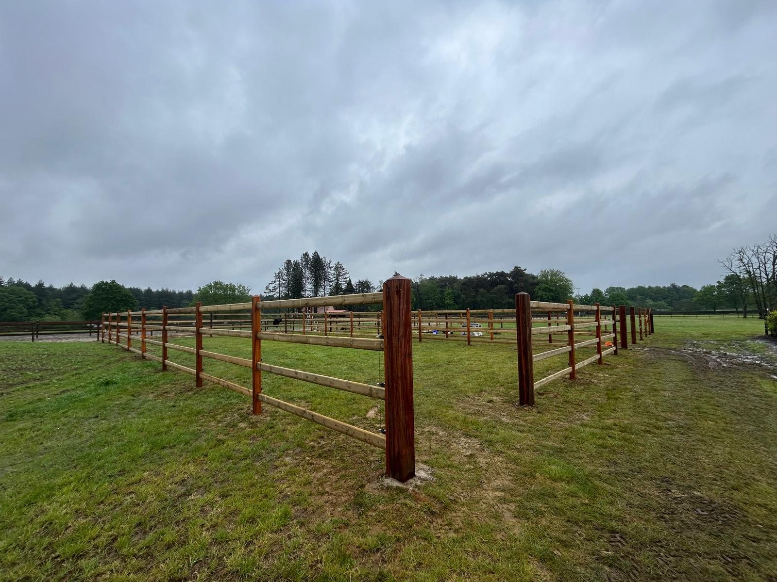 Four-rail horse fencing around a paddock with diamond-head okan corner posts