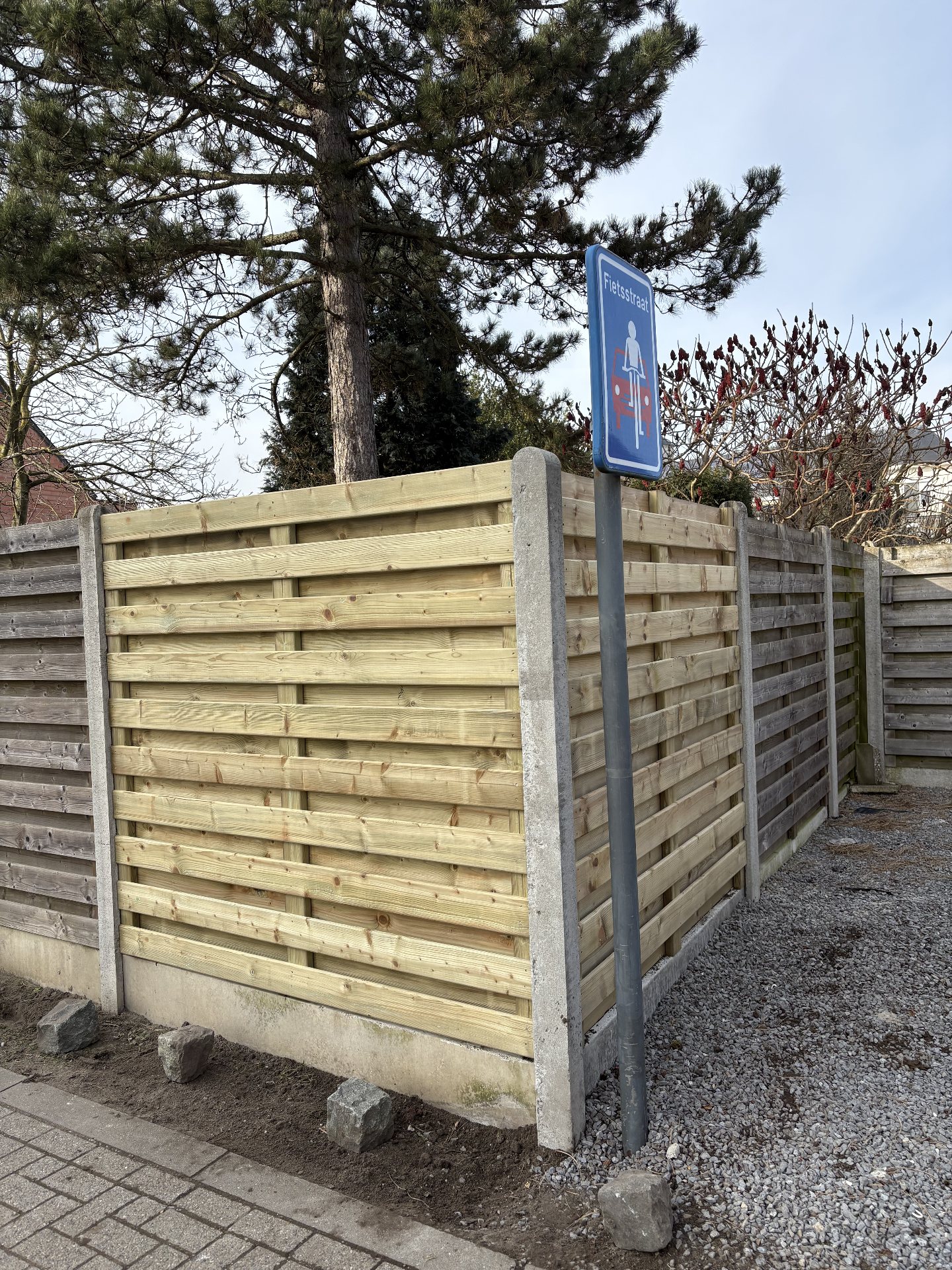 Tongue-and-groove fence panels between concrete posts and plinths